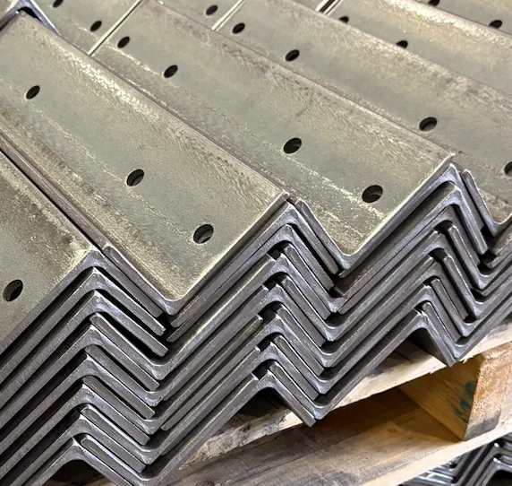 Stacked metal L-brackets with holes for screws on a wooden surface.