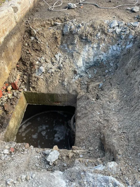 A hole in the ground with water coming out of it.