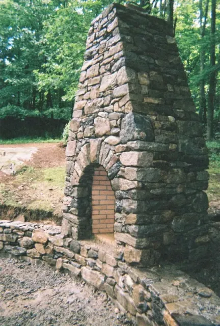 Freestanding outdoor stone fireplace with a full masonry chimney