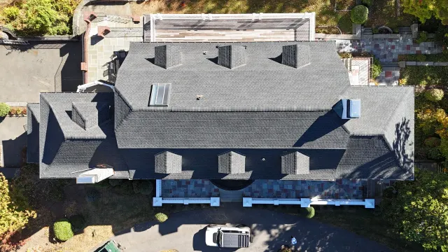 An aerial view of a large house with a car parked in front of it
