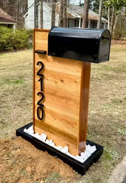 Black mailbox on a custom wood post with vertical house numbers