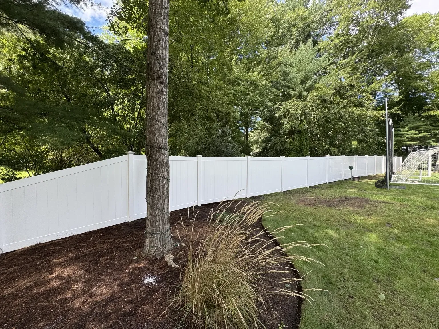 White vinyl privacy fence tapered to follow the property layout