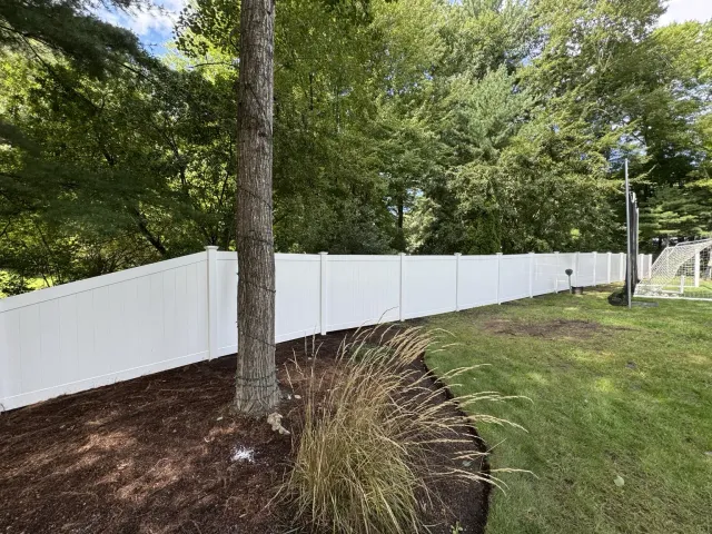 White vinyl privacy fence tapered to follow the property layout