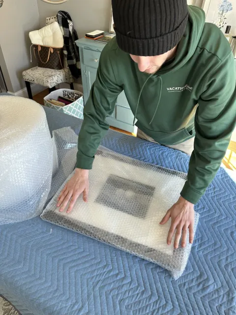 Mover wrapping a photo for Vacationland Moving Company