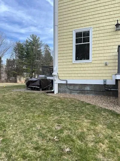 A yellow house with a large lawn in front of it.
