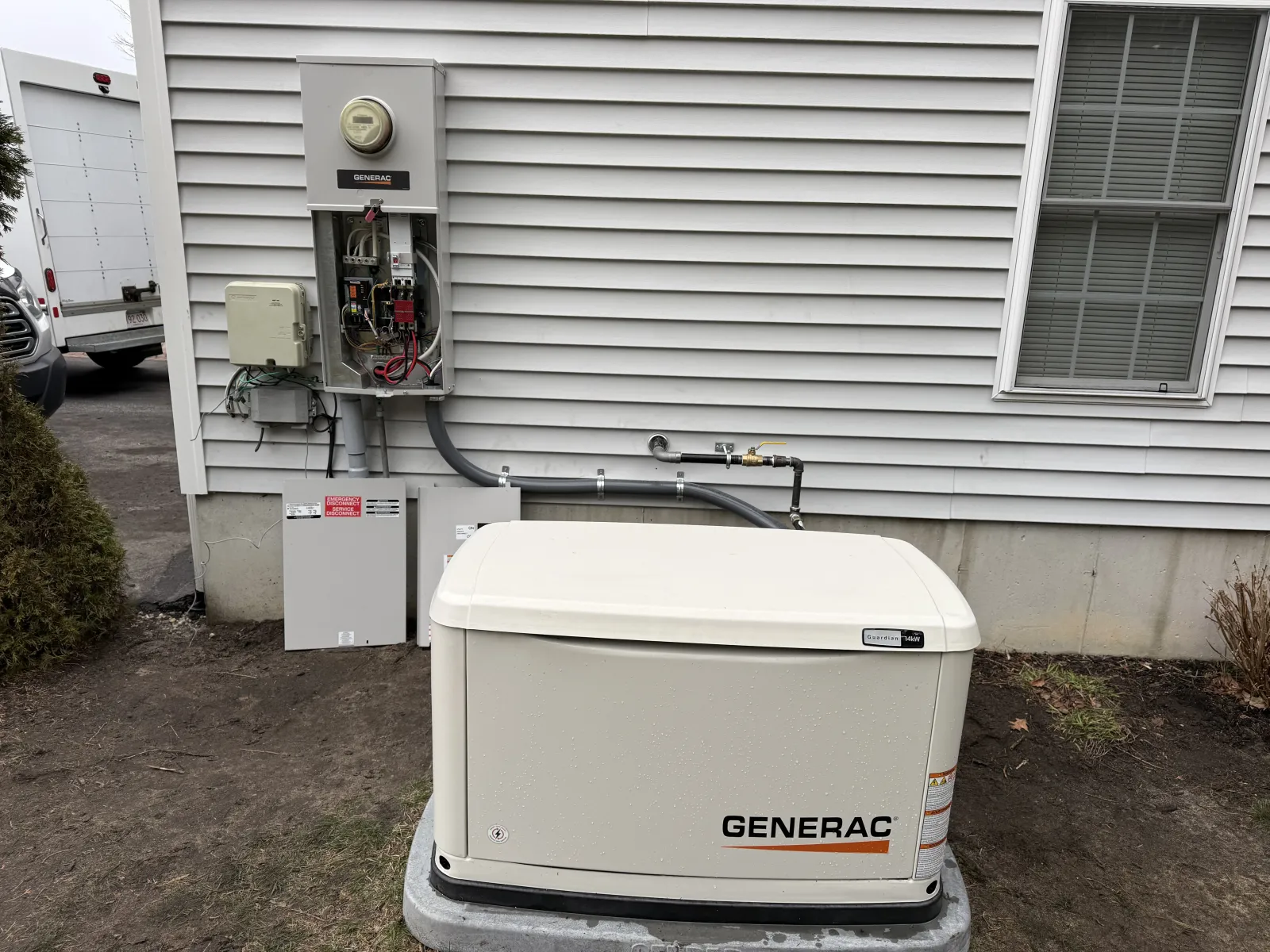 Generac whole-home generator installed alongside electrical service panel on a Taunton, MA residence