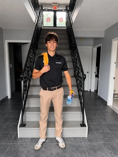 Noah, owner of Barone Cleaning Co., holding cleaning supplies