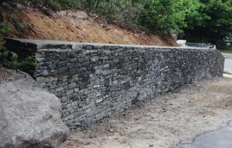 Dry-stacked stone retaining wall with hillside