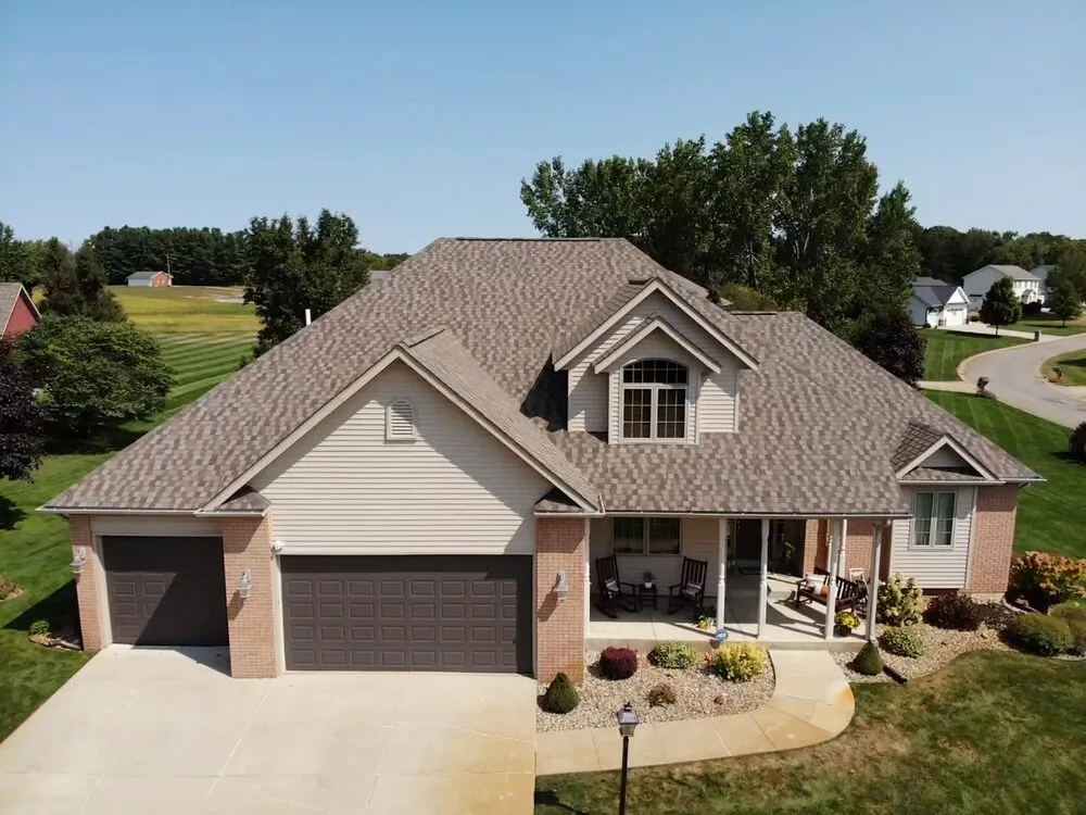 A spacious home featuring a large driveway and an attached garage.