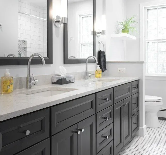 Elegant powder room renovation in Acton, MA, by Thomas Buckborough, with a framed mirror and a pedestal sink
