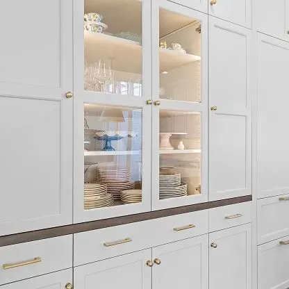 White kitchen cabinets with glass-front doors displaying dishes and glassware