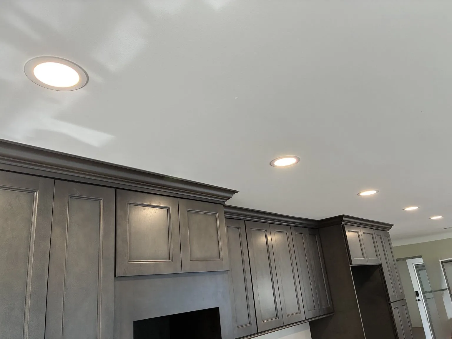 Finished kitchen with recessed lights at full brightness