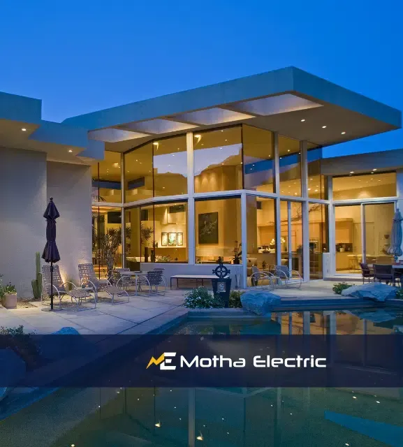 Modern residential exterior with stylish lighting, showcasing Motha Electric branding, emphasizing quality electrical services for homes.