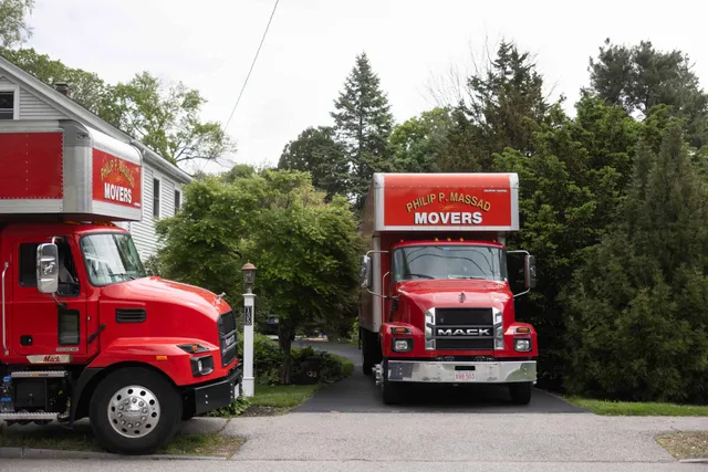 Two red trucks parked in front of a house.