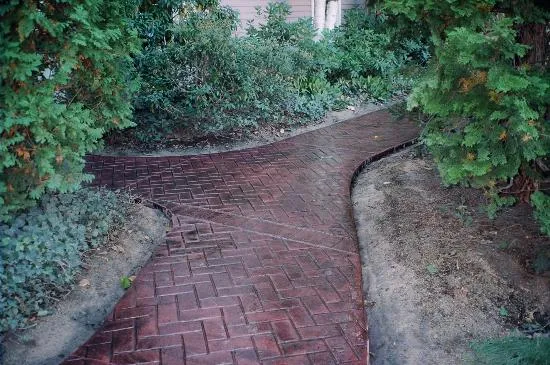 Red brick-pattern stamped concrete curved walkway