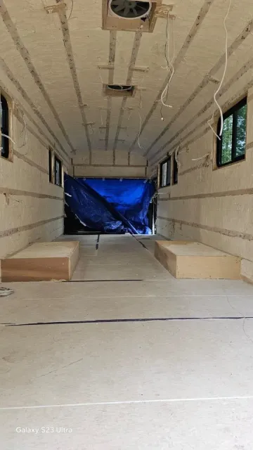 A large room with a lot of windows and a blue tarp on the ceiling.