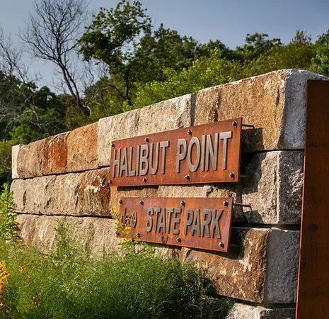 Stone entry sign with wildflowers in the background Halibut Point State Park Crowley Cottrell LLC Landscape Architecture