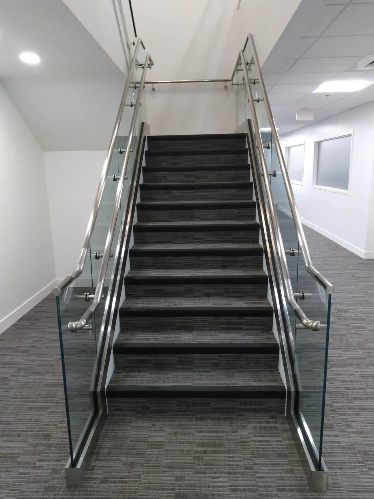 A set of stairs with a glass railing in a building.