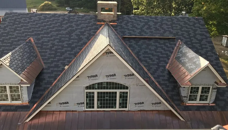 Newly shingled roof on a stone-front home