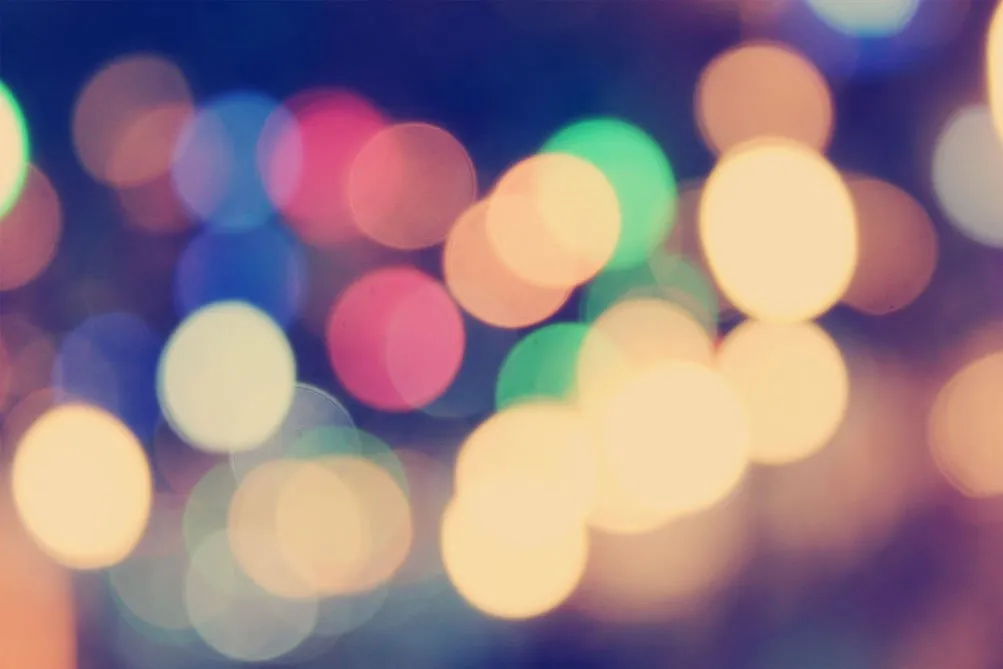 Blurred colorful lights in various sizes and hues, suggesting a festive or vibrant atmosphere.