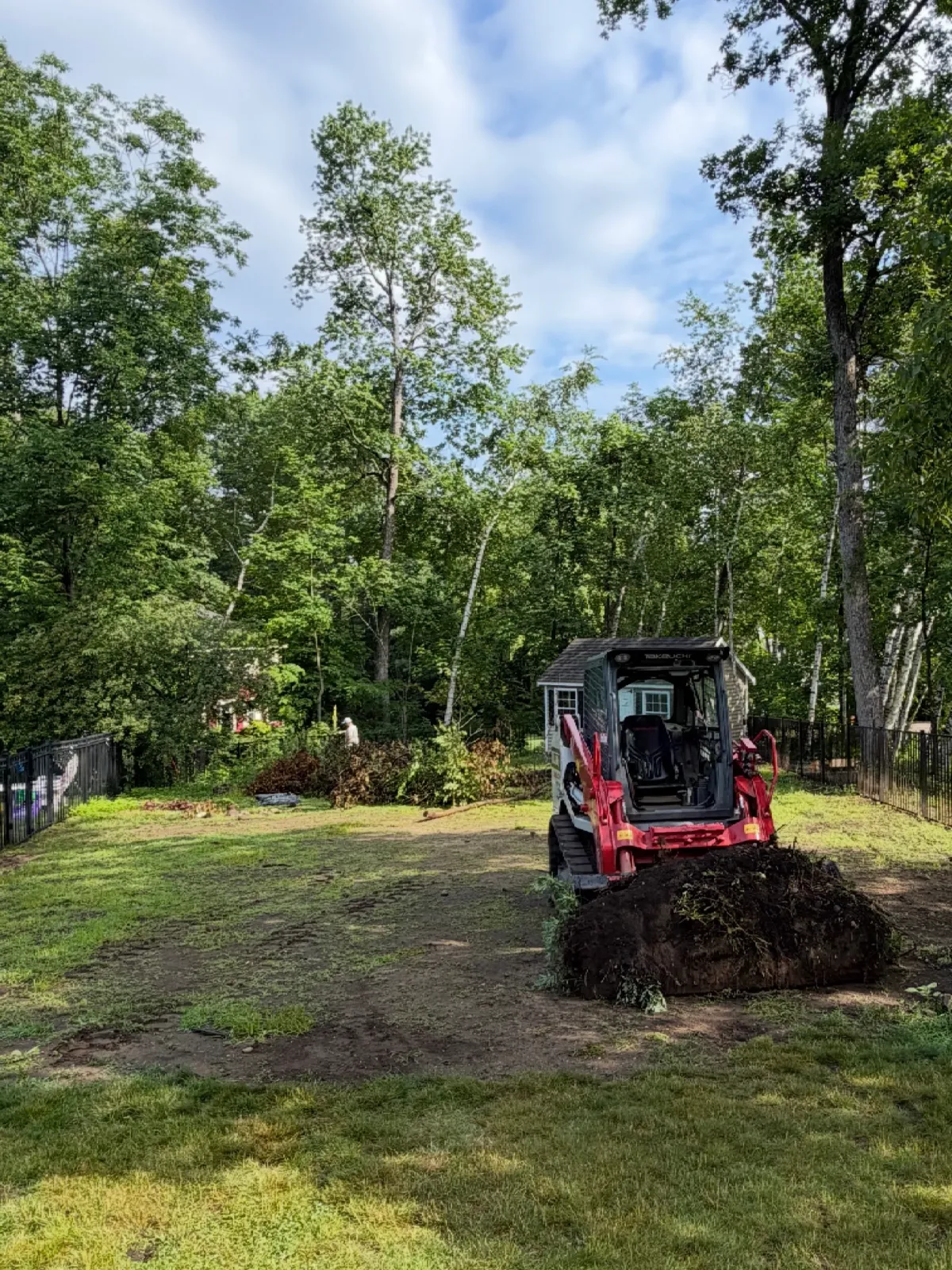 Excavator moving soil in garden setting