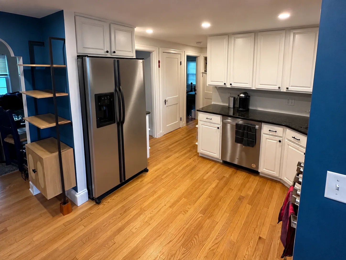 Freshly painted kitchen with white cabinets and a blue accent wall in a Sterling MA home