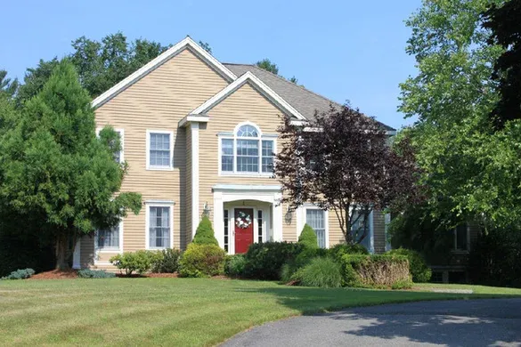 Tan colonial with pedimented entry and red door
