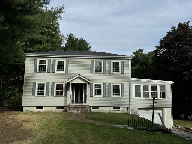Completed light-green vinyl siding installation by Storm King Roofing on a colonial home in Brockton, MA