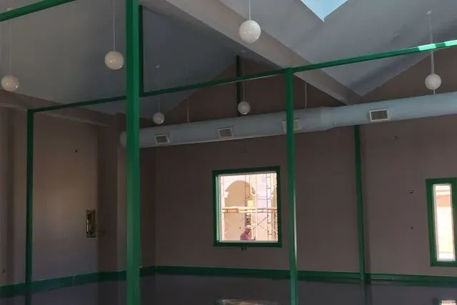 An empty room with green columns and a skylight