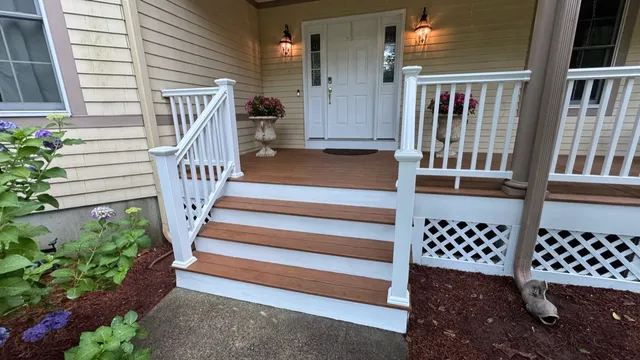 Front porch steps with white rails and columns