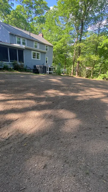 Uneven backyard leveled and prepped for seeding in Chelmsford, MA by Gardner’s Landscaping, LLC