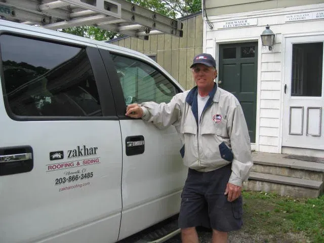 A man standing next to a truck that says Zakhar on it