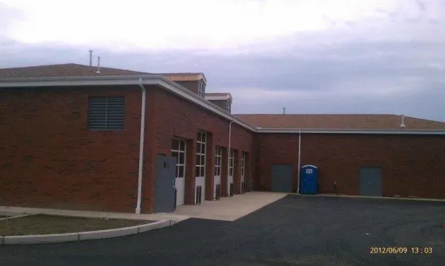 A brick building with a blue toilet in front of it