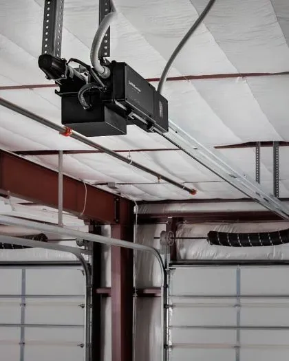 A man on a ladder is working on a garage door