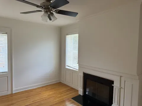 A made bed and dusted bedroom surfaces