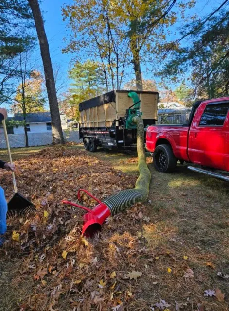 Crew raking leaves into the vacuum truck during a fall cleanup in Hudson, NH