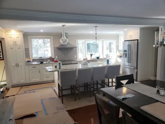 Newly renovated kitchen with a large island, stainless steel appliances, and cream cabinets.