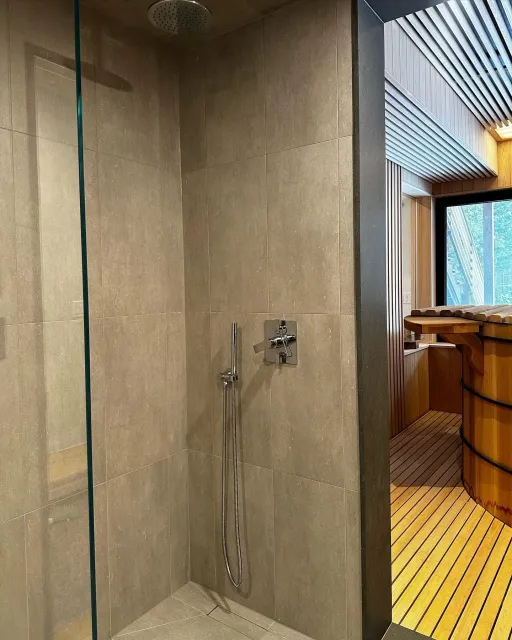 a bathroom with a walk in shower and a wooden tub