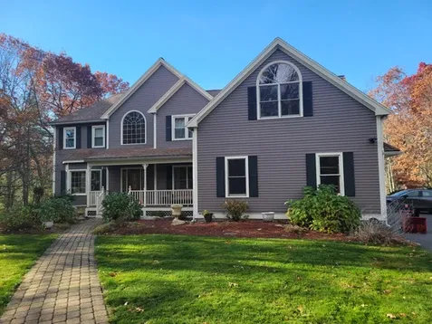 Home in Marlborough, MA with gray painted exterior, white trims and black shutters.
