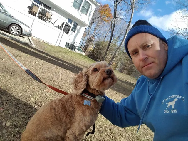 A man and his dog are outside in the yard.