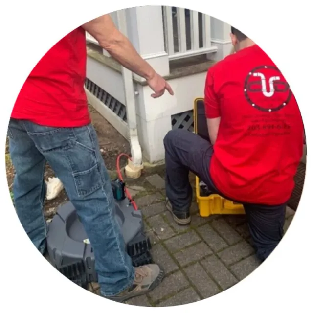 2 team members cleaning storm water drain outside