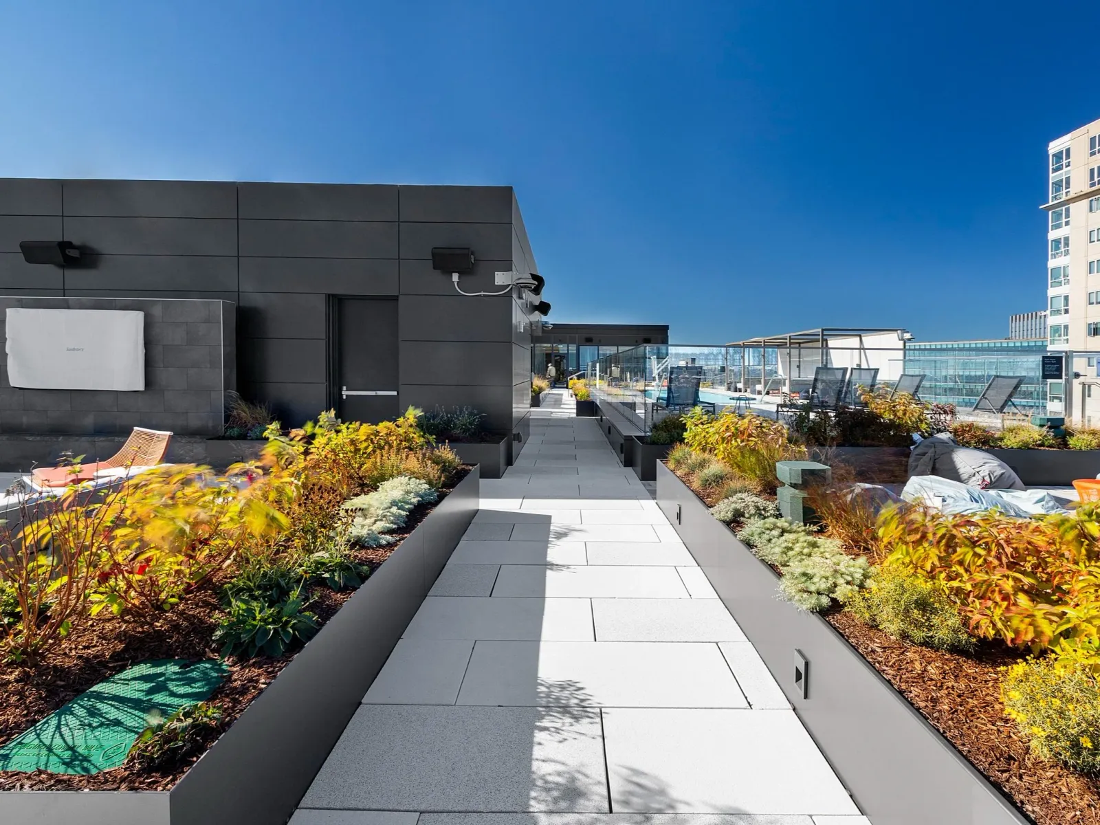 A urban rooftop hardscape and garden space in Boston installed by Xquisite Landscaping, a commercial landscape construction company working in the Greater Boston Area