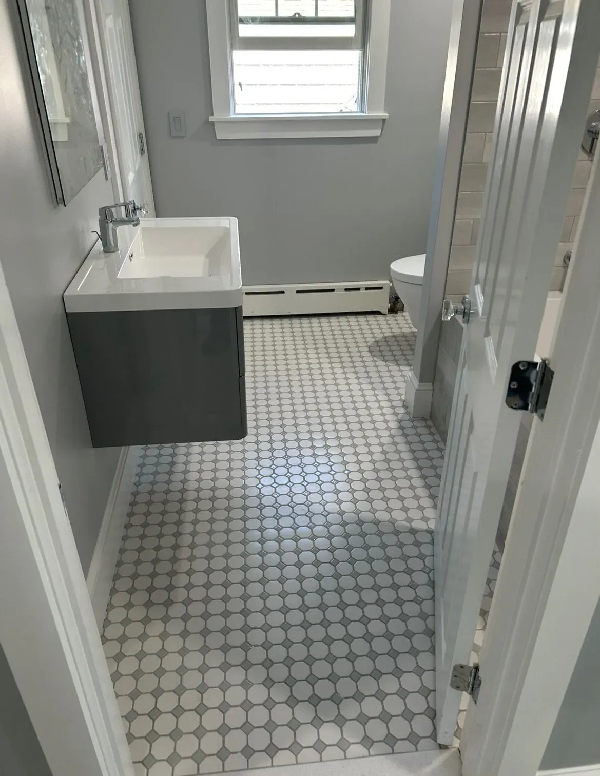 A bathroom with a sink , toilet and mirror.