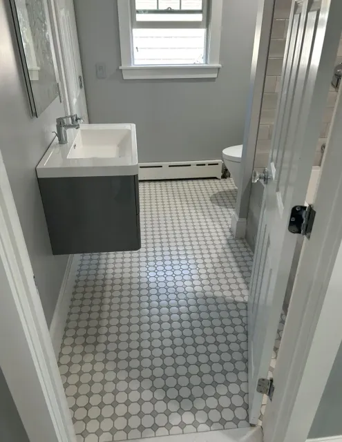 A bathroom with a sink , toilet and mirror.