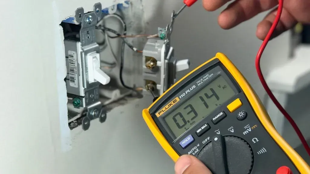 Hands testing electronic circuits with a multimeter.