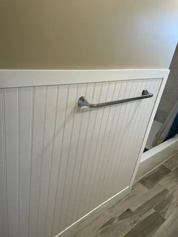 Repaired bathroom wall with PVC wainscoting
