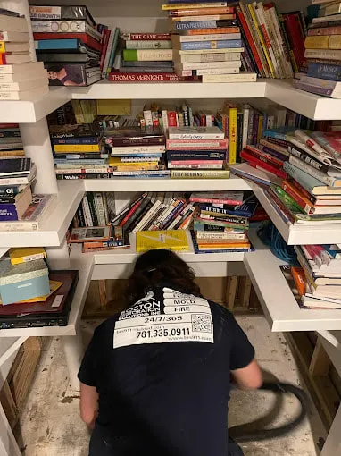 Worker Organizing Books in Closet