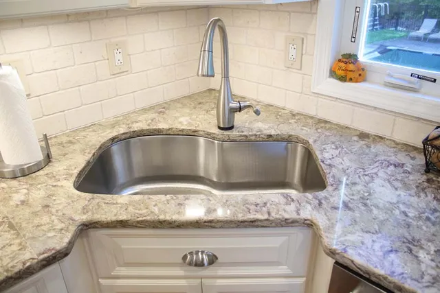 Undermount sink with granite counters and stone backsplash