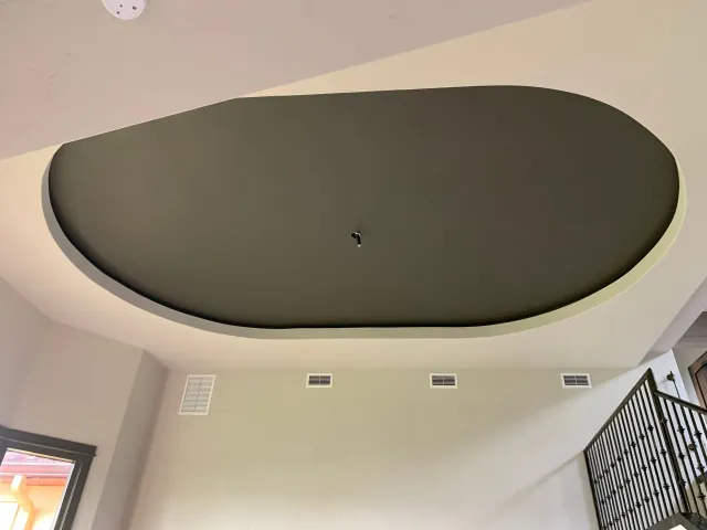 A ceiling in a room with a staircase in the background