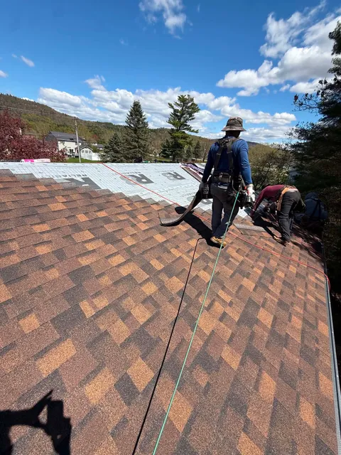 Crew laying shingles with harnesses on
